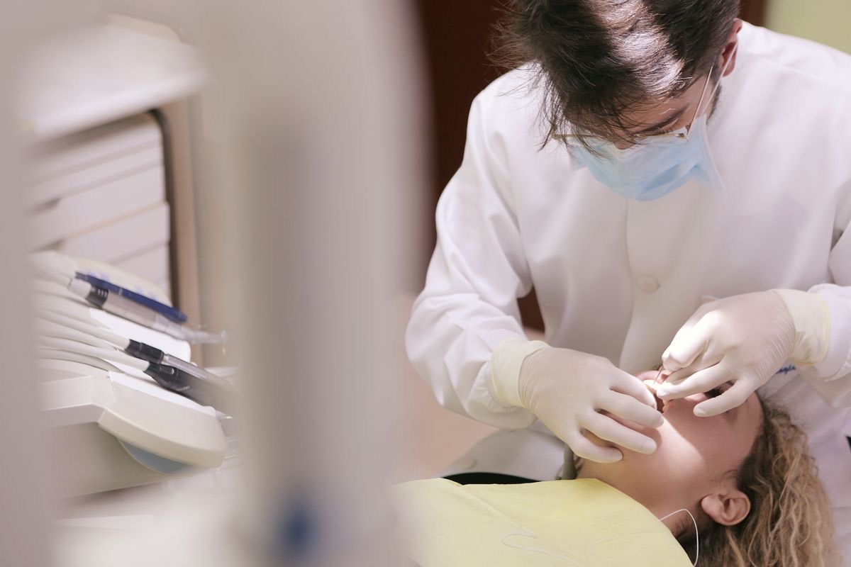 Dentist providing gum and periodontal care in clinic